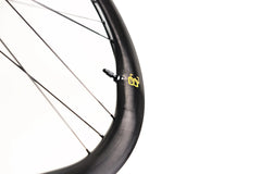 Close-up of Approved Cycling ATEM SilkRoad 3.8 wheel, detailing the innovative carbon fiber weave and tubeless valve.